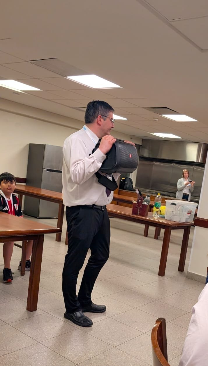 Members assisting with audio equipment during a devotional gathering on the trip