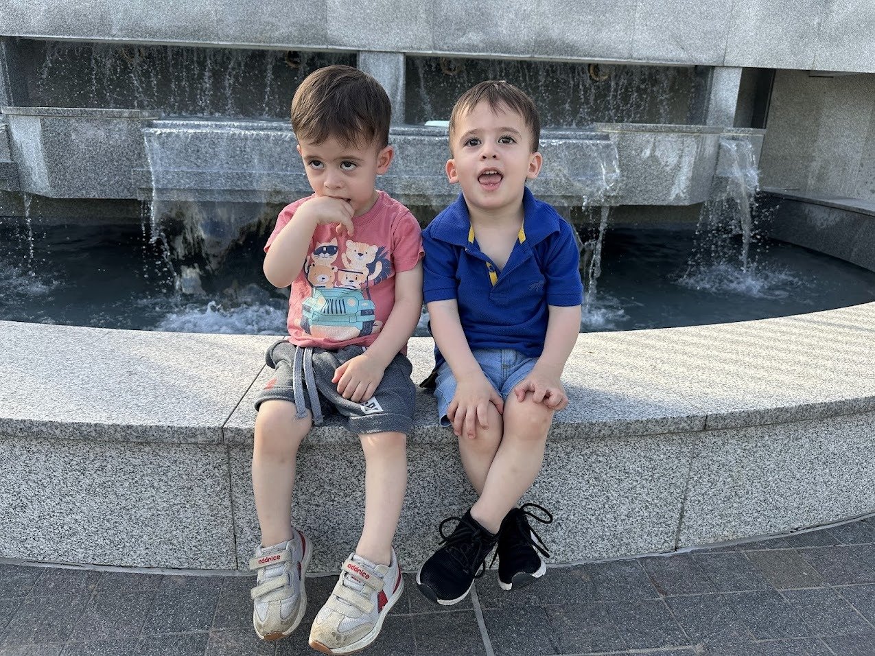 Twin children posing happily at the temple grounds during the trip